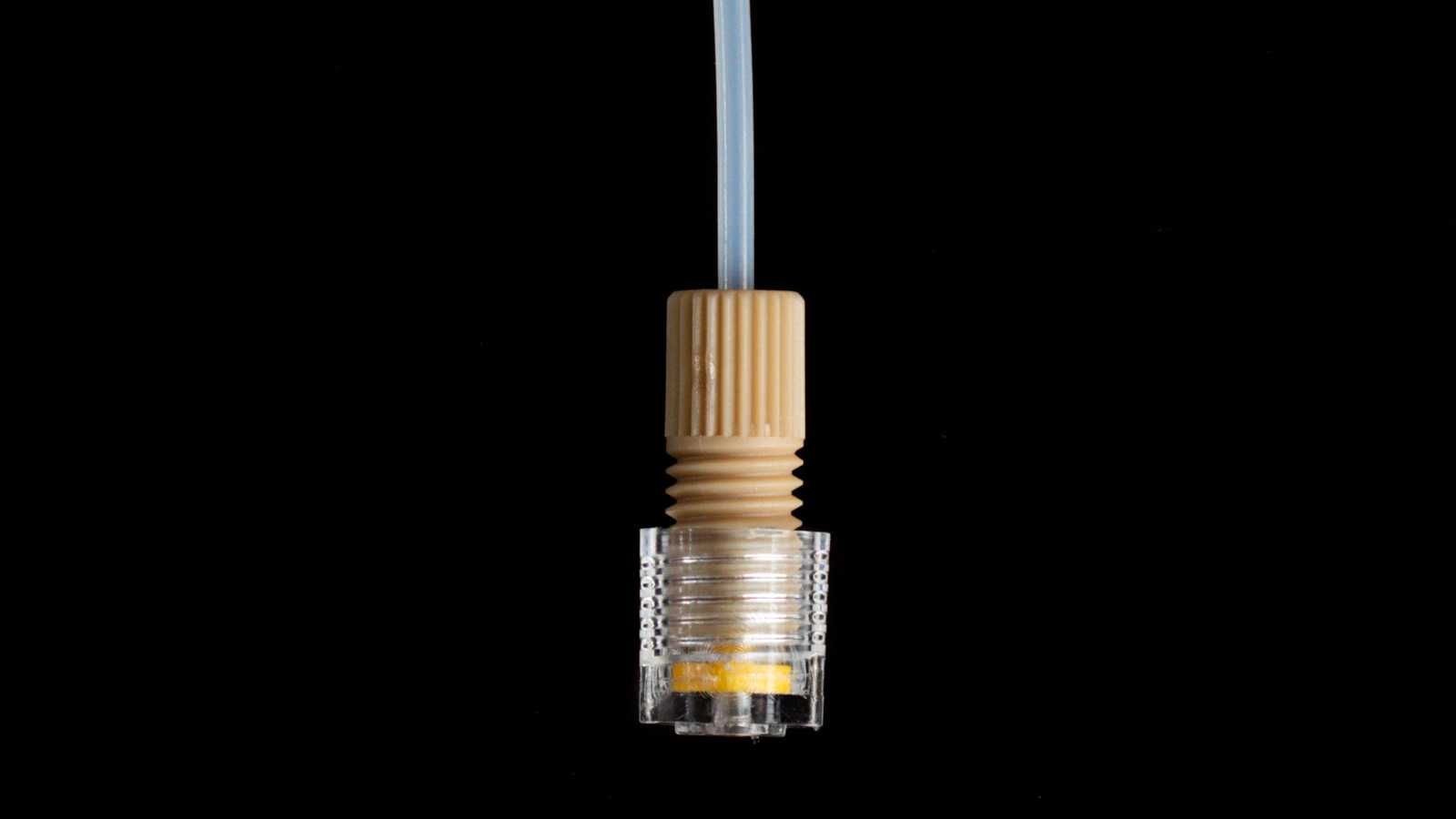 A super flangeless 1/4-28 capillary tube interface assembled with a 1/4-28 port. From top to bottom: tubing, nut, ferrule, and the 1/4-28 port.