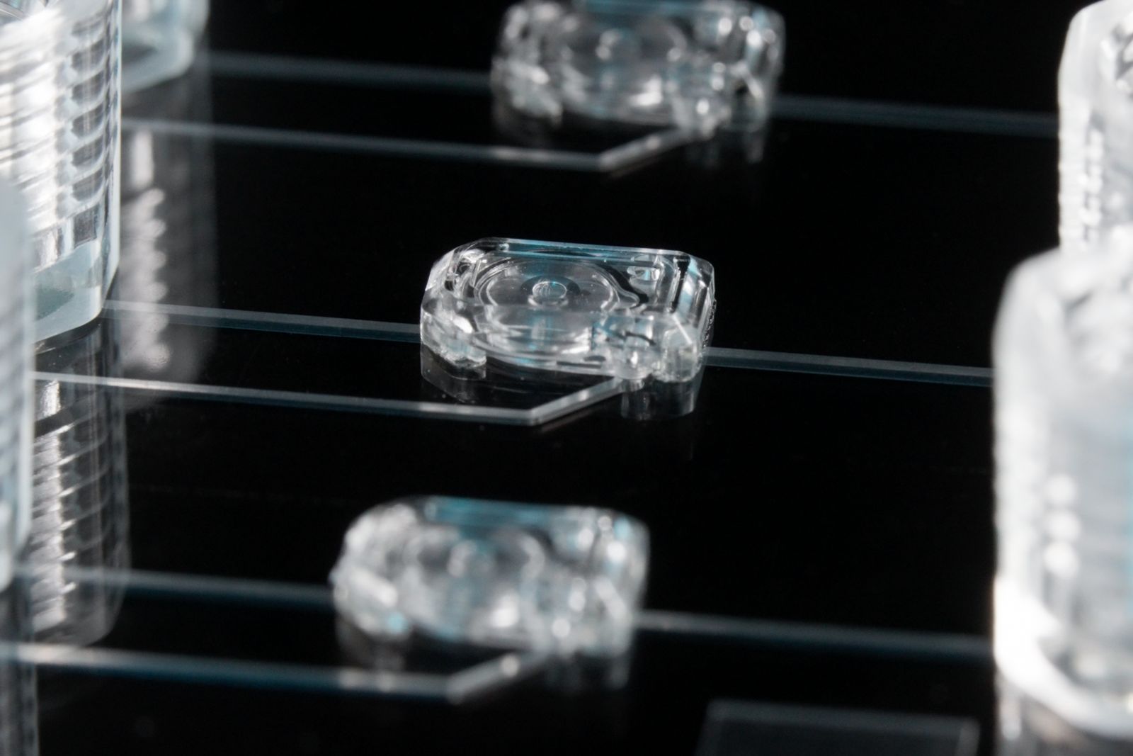 Three MV-1 microvalves on a microfluidic device. Channels connect the microvalves to the 1/4-28 ports next to them.