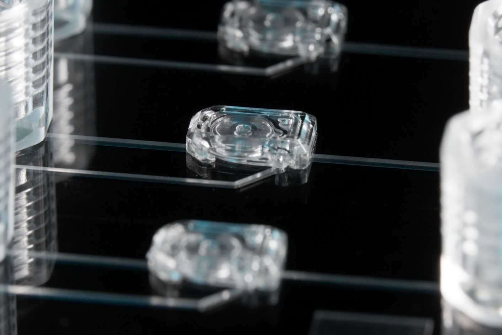 Three MV-1 microvalves on a microfluidic device. Channels connect the microvalves to the 1/4-28 ports next to them.
