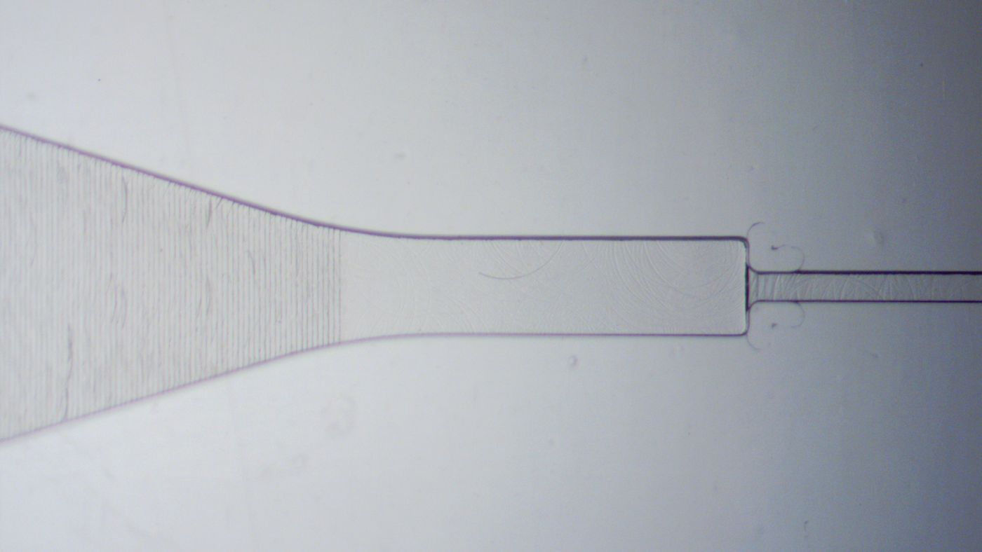 Close-up of a Transition Molded capillary valve and sloped microfluidic channel. The surfaces are smooth. All microfeatures are clearly defined.
